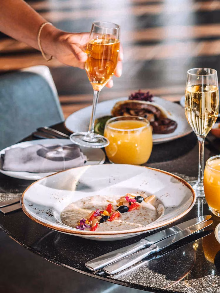 Jo'burg’s skyline glitters beyond the rim of an elegant glass of champagne, bubbly and bright. (Image courtesy of The Four Seasons Hotel).