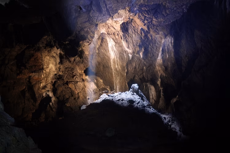 In the heart of the cave, a single opening lets through a ray of light, creating a spotlight surrounded by the never-ending dark. (Image is artists impression).