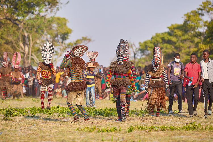 A group of makishi prepare to perform the traditional kuhunga dance. (Image by Nkwazi/Justine Kunda).