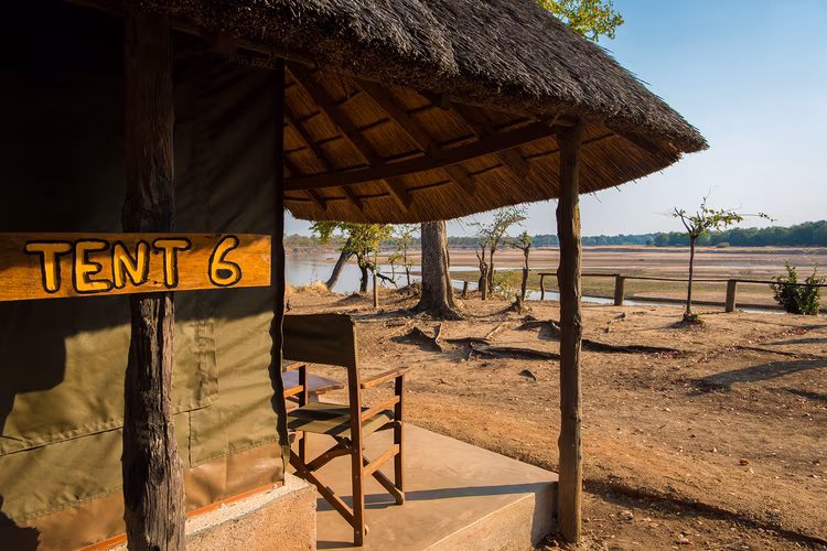 A set of rustic chalets is arranged around the lagoon and riverbank, each provided with a veranda to supply you with the best view. (Image courtesy of Wildlife Camp).